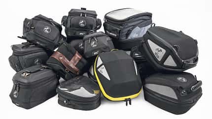 Hepco und Becker Tankrucksack, Hepco und Becker, Tankrucksack, Motorradgepäck, Motorrad-Zubehör, Tanktasche, Gepäcksystem Motorrad, Red Week, Studioaufnahme, Produktfotografie Das Foto zeigt mehrere Hepco und Becker Tankrucksäcke für Motorräder in einer Gruppenaufnahme. Die schwarzen Taschen in unterschiedlichen Größen besitzen Reißverschlüsse, sichtbare Markenlogos und teils halbfeste Formschalen; die Szene ist als Studioaufnahme vor weißem Hintergrund fotografiert. Der im Dateinamen genannte Kontext „Red Week“ deutet auf eine Aktions- oder Kampagnenzuordnung hin.