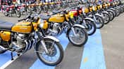 Große Reihe von Honda CB 750 Four Motorrädern bei einem Jubiläumsevent, zahlreiche Besucher und Zelte im Hintergrund.