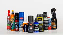 Kunststoffpflege, Pflegemittel, Autozubehör, Kunststoff-Tiefenpflege, Reinigungsprodukte, Pflegespray, Innenraumpflege, Fahrzeugpflege, Produktvergleich, Reinigungsmittel Gruppenbild verschiedener Kunststoffpflegeprodukte in Flaschen und Sprühdosen vor weißem Hintergrund.