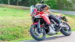 Motorradfahrer auf einer Moto Morini X-Cape 1200 in Kurvenfahrt auf Landstraße, Modellbezeichnung aus Dateiname nicht eindeutig.