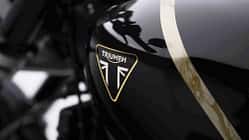 Triumph Speed Twin 1200 TFC Triumph Speed Twin 1200 TFC Sondermodell mit schwarzem Tank, goldener Zierlinie, rundem Scheinwerfer, tiefem Lenker und sportlicher Sitzbank in Seitenansicht vor dunklem Hintergrund