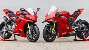 Ducati Panigale V2 S und Ducati Panigale V4 S nebeneinander auf Asphalt vor grauer Wand, beide in Rot mit Rennbereifung.