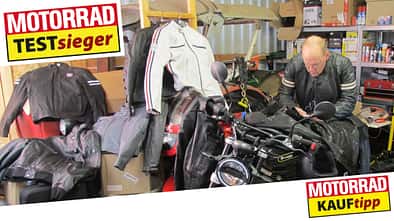 Lederjacken, Werkstatt. Mann lehnt über Motorrad.