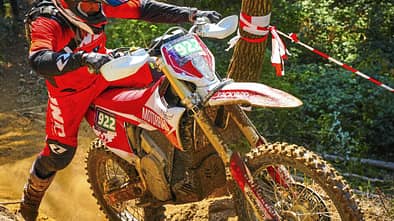 MOTORRAD fuhr die Stark Varg EX 52 Stunden und 1.156 Kilometer in reinen Enduro-Wettbewerben. Die Elektro-Enduro mit 80 PS machte keinerlei Probleme. Motocross-Fahrer auf Enduro-Motorrad in Aktion bei Offroad-Geländefahrt, Startnummer 922, im Wald.