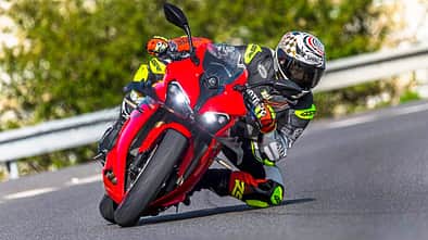 QJM SRK 800 RR in Kurvenfahrt auf der Landstraße, Fahrer in Racing-Lederkombi.