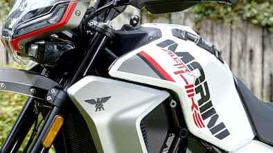 Detailaufnahme eines Adventure-Motorrads mit dem Schriftzug 'Morini' und 'X-Cape 650' auf dem Tank. Das Motorrad steht im Freien, im Vordergrund sind Frontverkleidung, Windschild und Motor zu sehen.