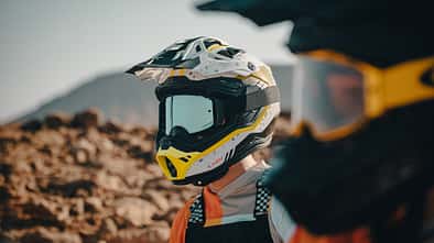 NEXX X.RALLY Offroad-Helm in Weiß mit Offroad-Brille, Nahaufnahme im Outdoor-Gelände.