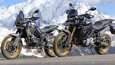 Kove 800 X Pro, Voge DS 900 X, Alpen Masters 2026 Mid-Adventure Asien, Motorradvergleich, Reiseenduro Zwei Mid-Adventure-Motorräder asiatischer Hersteller vor schneebedeckten Alpenbergen, aufgenommen beim Alpenmaster-Event 2026.