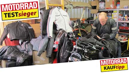Lederjacken, Werkstatt. Mann lehnt über Motorrad.