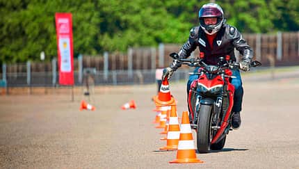 Motorradfahrer bei einem ADAC-Motorrad-Sicherheitstraining auf dem Sachsenring, fährt Slalom zwischen Pylonen.