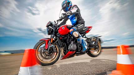 Triumph Trident 800 Motorrad bei dynamischer Fahrprobe mit Fahrer im Slalom zwischen Pylonen.