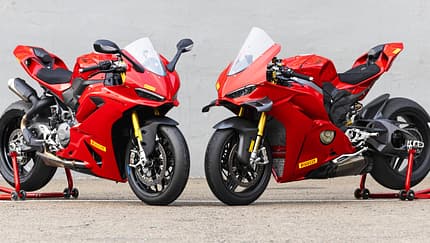 Ducati Panigale V2 S, Ducati Panigale V4 S, Superbike, Sportmotorrad, Rennmotorrad, Ducati, Zweizylinder, Rennstrecke, Motorradtechnik, Italienisches Motorrad Ducati Panigale V2 S und Ducati Panigale V4 S nebeneinander auf Asphalt vor grauer Wand, beide in Rot mit Rennbereifung.