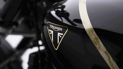 Triumph Speed Twin 1200 TFC Triumph Speed Twin 1200 TFC Sondermodell mit schwarzem Tank, goldener Zierlinie, rundem Scheinwerfer, tiefem Lenker und sportlicher Sitzbank in Seitenansicht vor dunklem Hintergrund