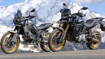 Zwei Mid-Adventure-Motorräder asiatischer Hersteller vor schneebedeckten Alpenbergen, aufgenommen beim Alpenmaster-Event 2026.