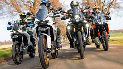 CFMOTO 800MT-X, KOVE 800X-Pro, KTM 790 ADVENTURE, VOGE DS800X RALLY, Mid-Reiseenduro, Motorradvergleich, Straßentest, Adventure-Bike, Reiseenduro, Allee Vier Mid-Reiseenduros der Modelle CFMOTO 800MT-X, KOVE 800X-Pro, KTM 790 ADVENTURE und VOGE DS800X RALLY fahren nebeneinander auf einer Allee.