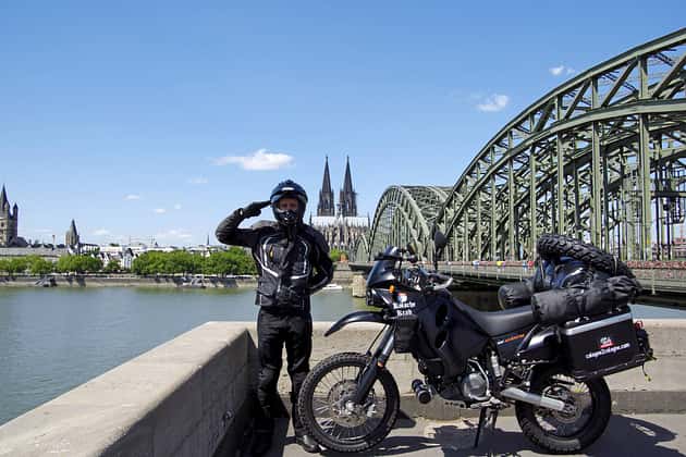 Enduro de voyage, voyage à moto, Cologne, pont Hohenzollern, cathédrale de Cologne, motocycliste, vélo d'aventure, scène urbaine, bagages de moto, Rhin Sa compagne de voyage, une KTM LC4 Adventure, a été modifiée avec différentes pièces d'enduro, un garde-boue haut, une peinture noire, une grille de lampe auto-construite et un filtre à air sport
