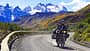 Reiseenduro-Motorrad auf Schotterstraße in Patagonien, Chile, mit schneebedeckten Bergen, den Anden, im Hintergrund.